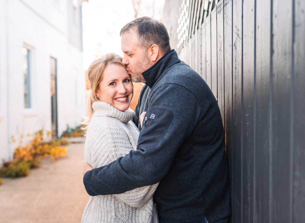 Couple sharing a loving moment with a kiss on the forehead - family photo by Leslie Q Photography
