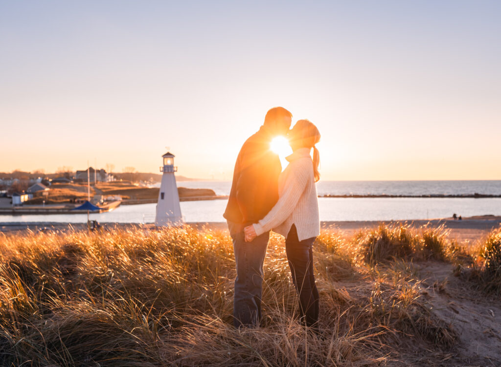 Couple kissing at sunset by the lighthouse in New Buffalo Beach
