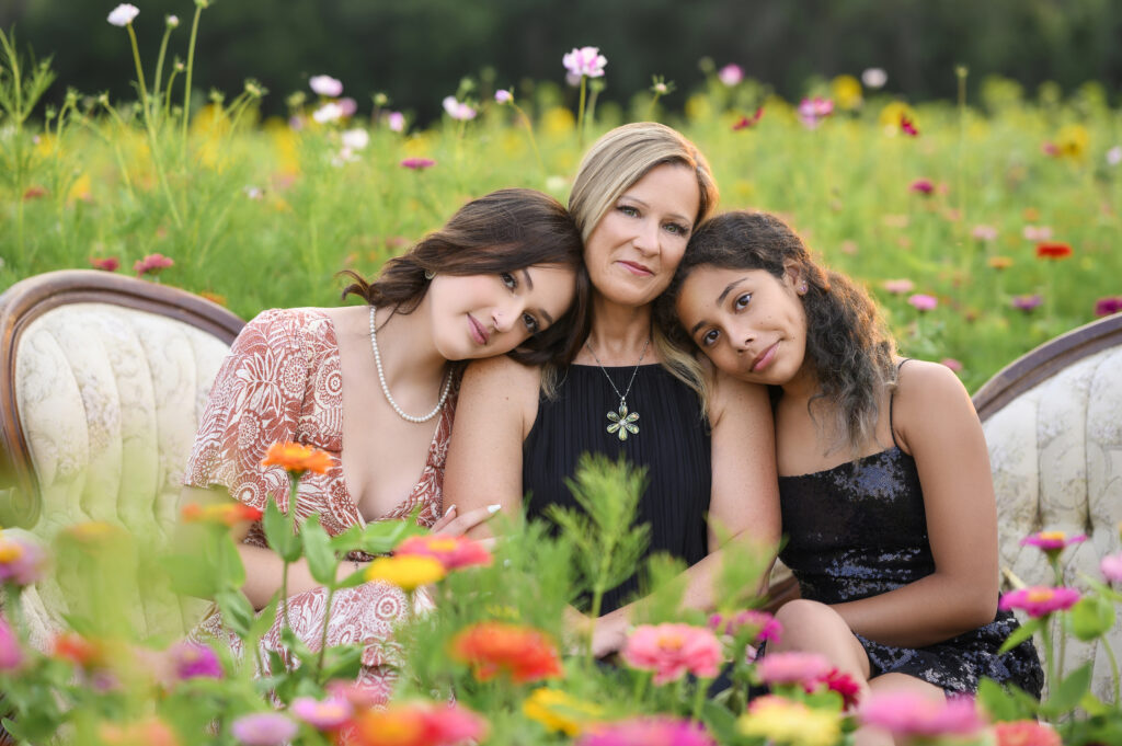 Outdoor senior portrait just outside of south bend in flower field at Thistleberry Farms of mother and daughter in a touching moment just before senior graduation. 
